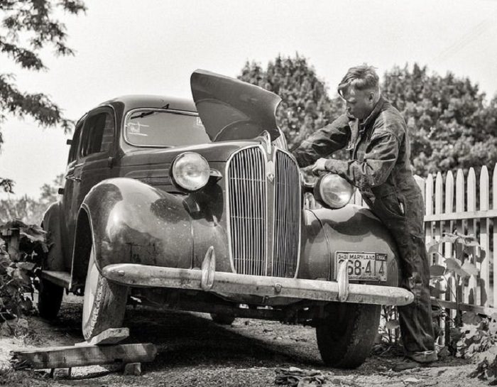  Fotografías De Eventos De Los Años 30 y 40 Hombre reparando su auto, 1934