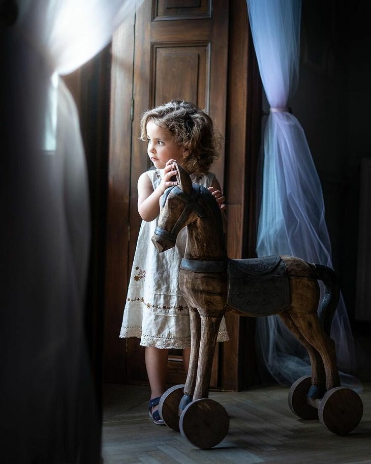 Fotos Mágicas Que Capturan El Encanto De La Infancia, Niña con su caballito de madera