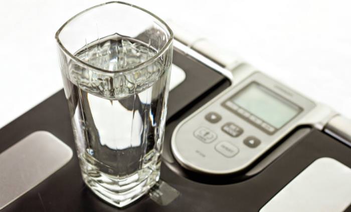 Buenos hábitos dietéticos,vaso de agua en una balanza