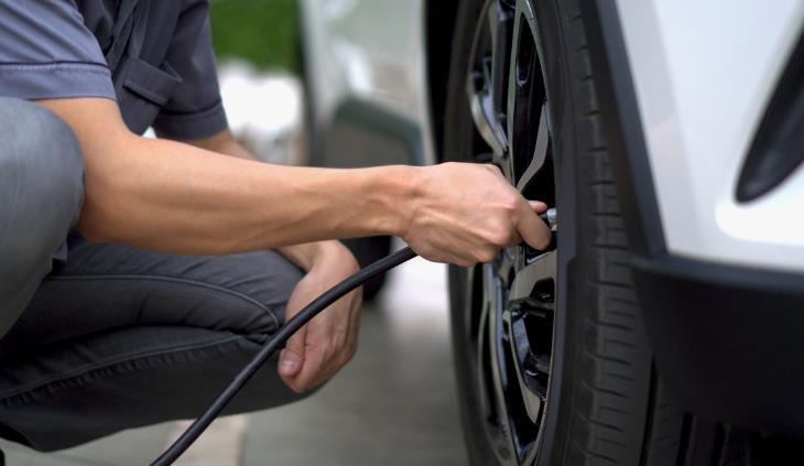 Manual Del Cuidado De Los Neumáticos, hombre poniendo aire a los neumáticos