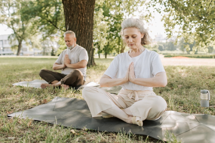 Yoga para diabéticos hombre y mujer mayores practicando yoga al aire libre