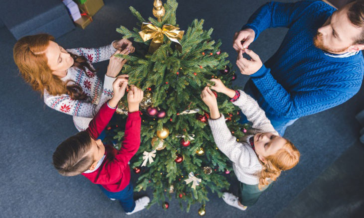 Precauciones De Seguridad En Navidad, familia decorando árbol de navidad