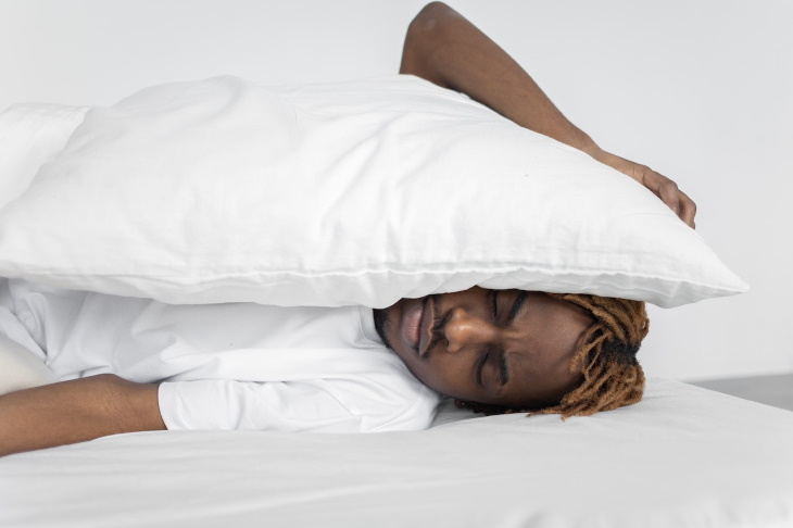 Sueño Bifásico, hombre pone sobre su cara una almohada