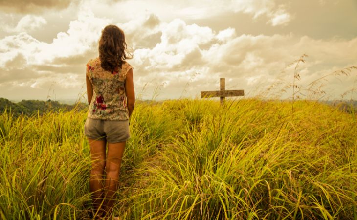 6 Consejos Para El Duelo, mujer mirando una cruz en un campo