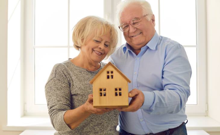 abuelos sostienen un modelo de casa