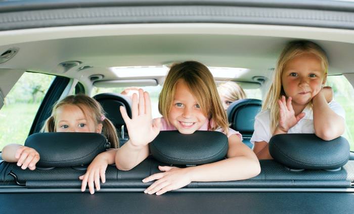 Niños sentados en el asiento trasero de un auto