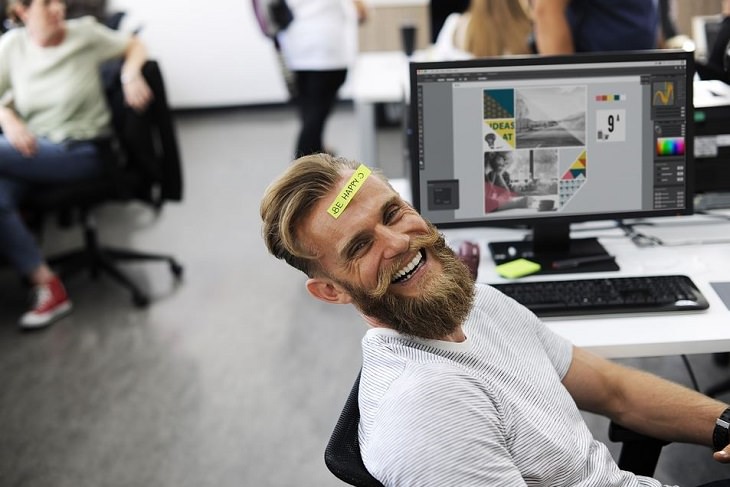 Cómo Equilibrar El Trabajo Con La Familia, hombre sonriendo en la oficina