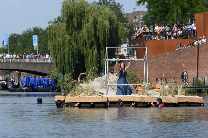 Desfile En El Agua Celebra El Arte De Hieronymus Bosch, mujer sostiene una pieza de metal