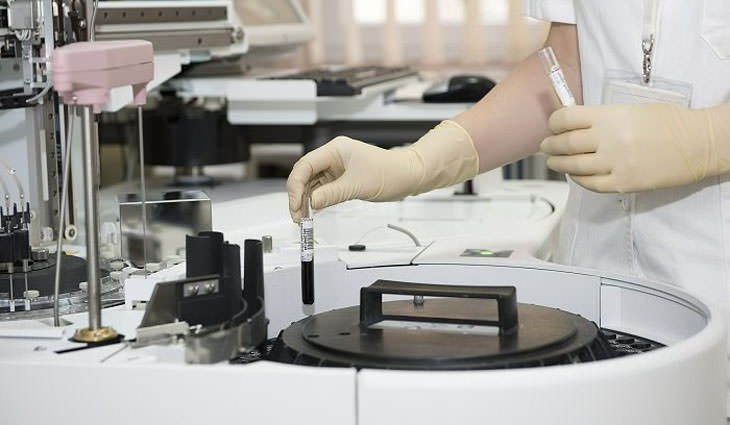 Identificación de la disfunción tiroidea: las manos de un investigador insertan tubos de ensayo en una herramienta de prueba de laboratorio