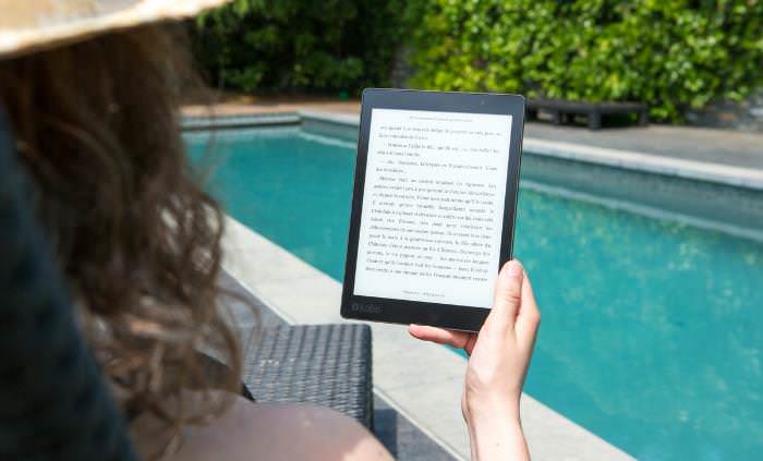 Libro electrónico gratis, mujer leyendo un libro electrónico en la piscina