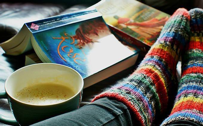 piernas de mujer junto a un libro y un plato de sopa