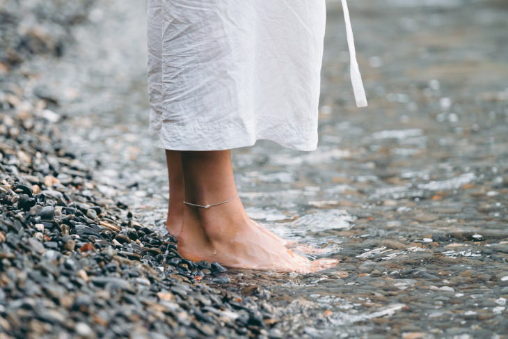Guía de 5 pasos para el cuidado de los pies en verano mujer descalza en aguas poco profundas