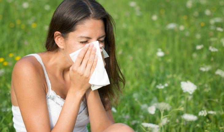 oral allergy syndrome- woman blowing nose in a field