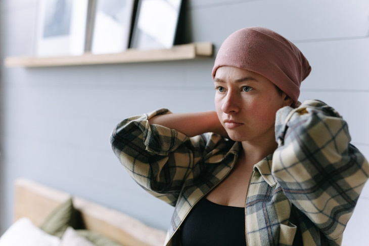 Una adolescente con cáncer de hígado se pone el pañuelo en la cabeza