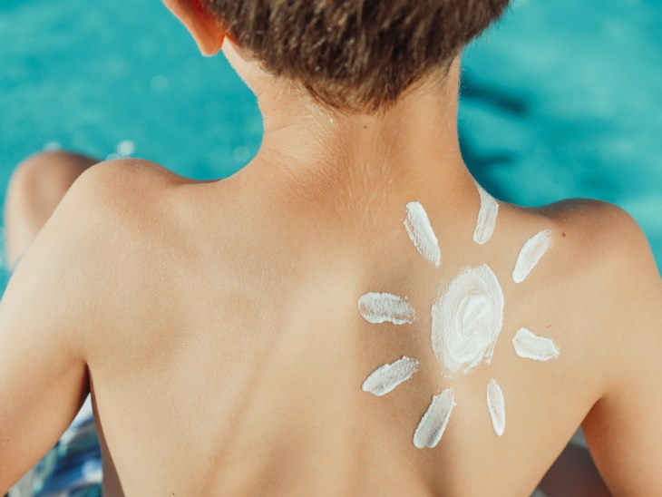 Eliminación de manchas de crema solar niño con crema solar en la piel