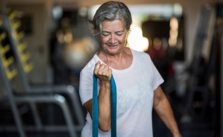 ejercicio para mayores - mujer estirando una banda de resistencia 