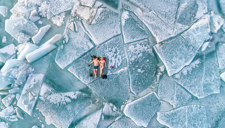 Fotos con drones, pareja toma el sol sobre el hielo