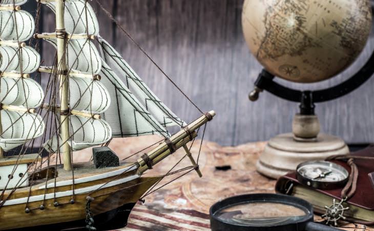 Brújula, mapa, globo terráqueo, barco en miniatura 