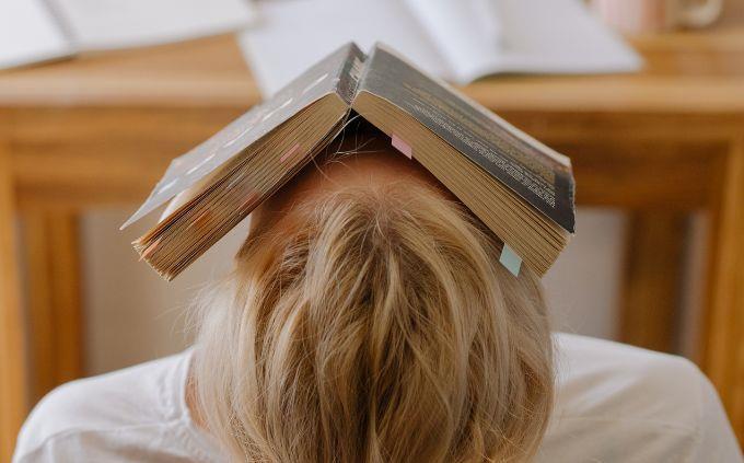 Prueba cuál es tu estado mental: mujer con un libro en la cabeza