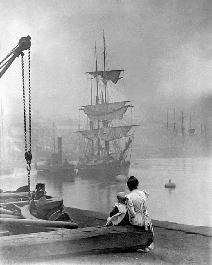 Una madre y su hija observan cómo un velero navega por el Támesis con la ayuda de un remolcador de vapor, Londres, ca. 1880