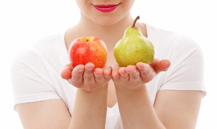 mujer sosteniendo manzana y pera