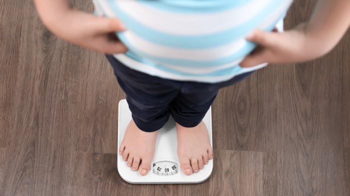 Datos Sobre Obesidad Infantil, niño se pesa en una báscula