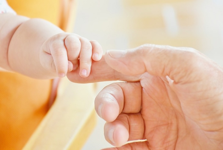 Los 10 Mandamientos De La Buena Crianza,  padre sostiene la mano de su bebé