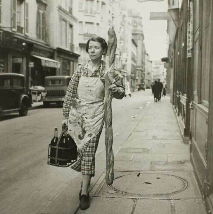 Fotos Históricas, "Una mujer francesa con un baguette y seis botellas de vino en París, Francia (1945)"