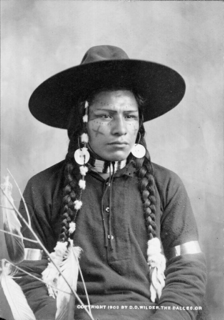 Fotos Históricas, "Retrato de un indio Wasco con un rostro decorado, plumas y adornos de cuentas (1903)"