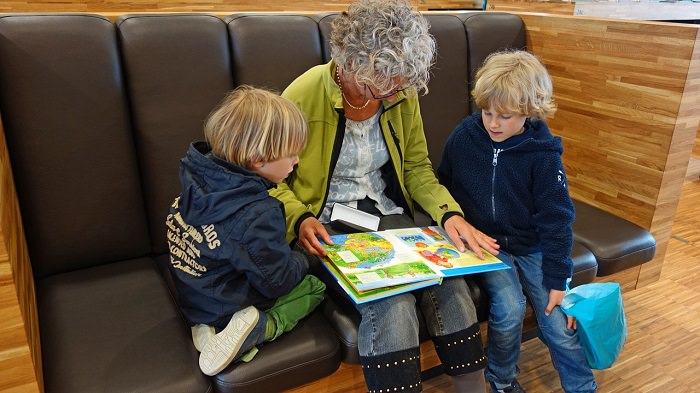 Beneficios De Pasar Tiempo Con Tus Nietos, abuela leyendo un cuento a sus nietos