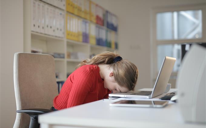 Lo que tus hábitos de sueño revelan sobre tu futuro: Una mujer duerme sobre su computadora