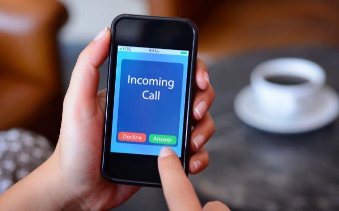 Estás agotado o estresado: una mano sosteniendo un teléfono con una llamada entrante