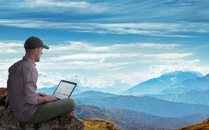 ¿Está agotado o estresado?: Un hombre trabaja frente a una computadora en el monte