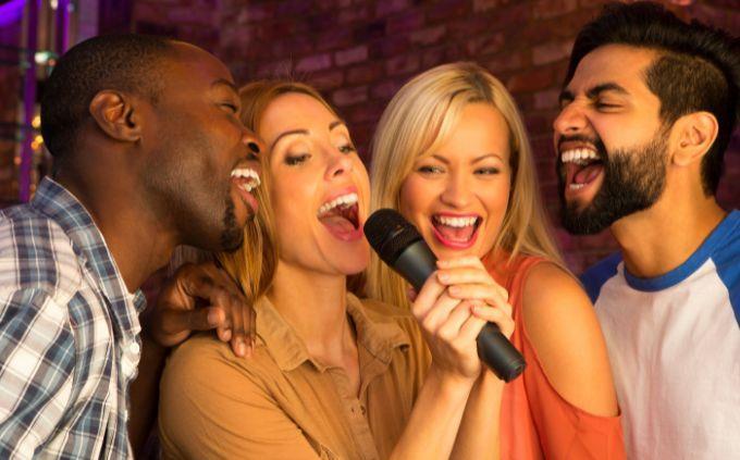 ¿Eres una persona predecible? Gente cantando frente a un micrófono.
