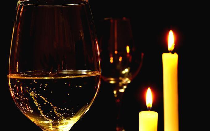 Prueba de flores y romance: velas y una copa de vino
