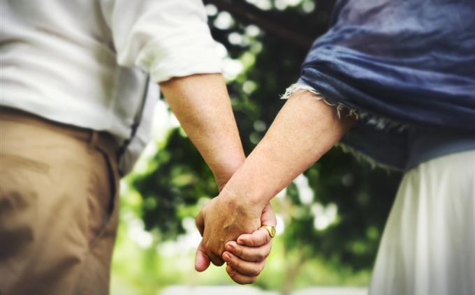 Prueba de flores y romance: una pareja cogida de la mano