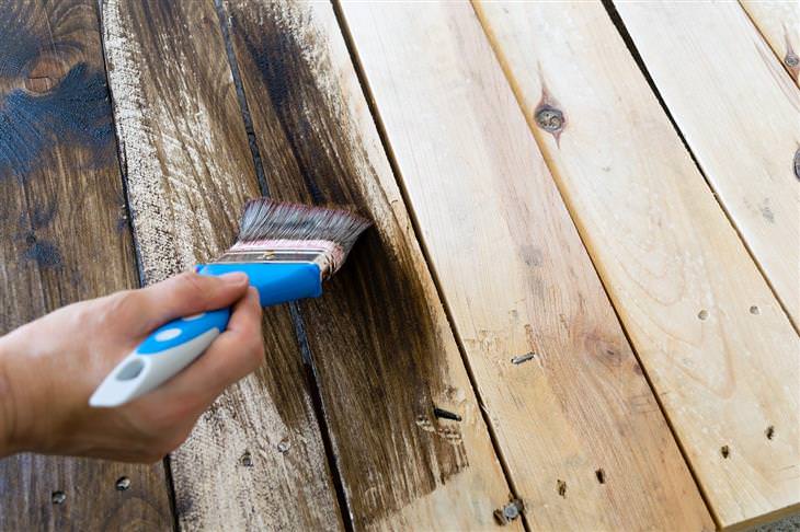 Information about wood in furniture: Person painting wood with a brush