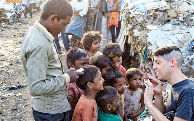 Un hombre ayudando a niños de un país del tercer mundo.