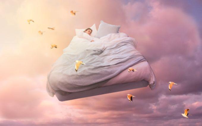 Dónde estarás dentro de 5 años según tus sueños: una mujer durmiendo en una cama volando en el cielo