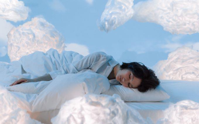 Dónde estarás dentro de 5 años según tus sueños: Una mujer durmiendo entre nubes