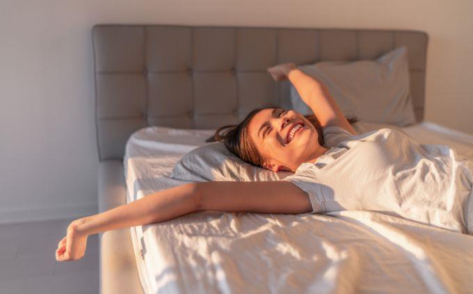 ¿En qué momento del día estás? Una mujer despertando en la cama.