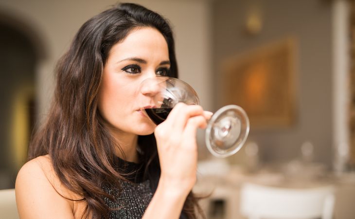 Is a glass of red wine a day healthy: Woman drinking red wine