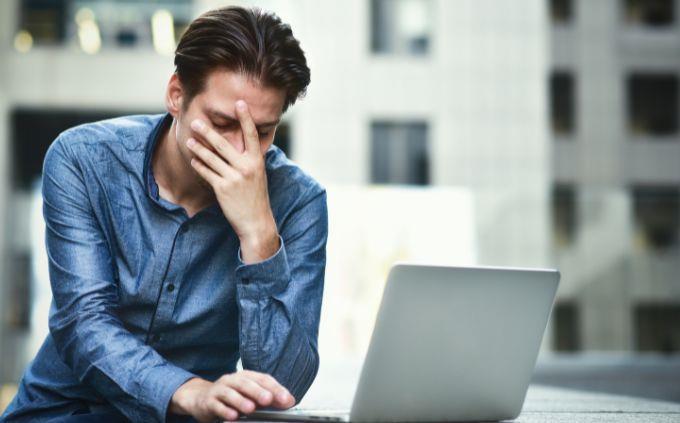 Cuál es la leyenda que cuenta la historia de tu vida: un hombre frente a una computadora con una mano en la cara