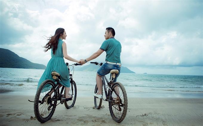 Prueba de color y necesidades de amor: una pareja en bicicleta en el mar